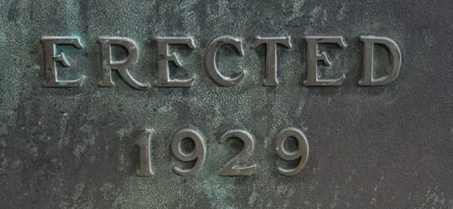 Close-up of the raised ERECTED 1929 lettering on the Gulf Building plaque